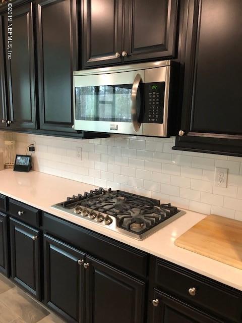 188 Antilles Road St. Augustine, FL 32092 - Photo 7 of 43 a kitchen with wooden cabinets and a stove top oven