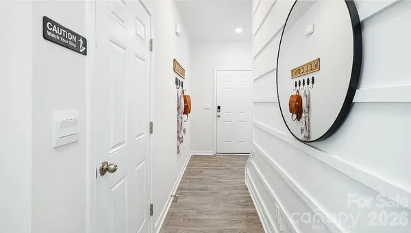 a view of a hallway with wooden floor and entryway