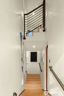 a view of a hallway with wooden floor and staircase