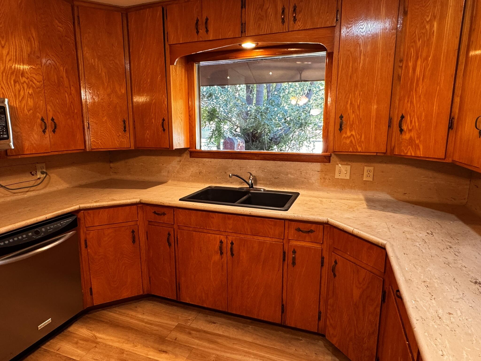 701 Zephyr Plainview, TX 79072 - Photo 12 of 29 a kitchen with stainless steel appliances granite countertop wooden cabinets a sink and a large window