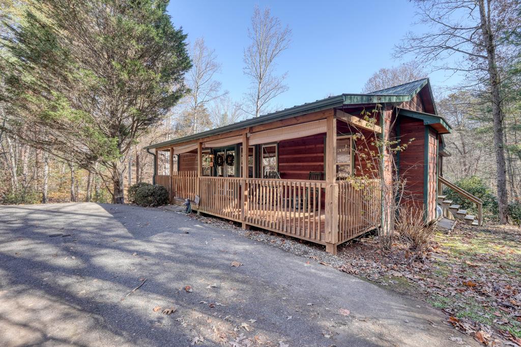 a view of a small house with a small yard and wooden fence