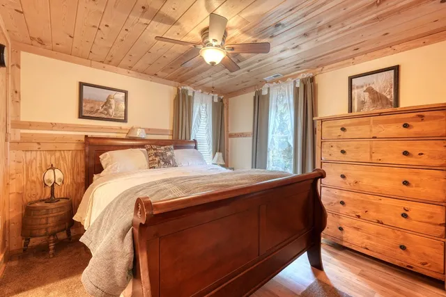 a bed sitting in a spacious bedroom next to a window