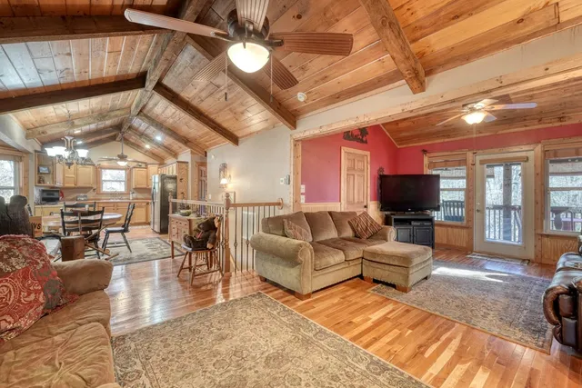 a living room with furniture a flat screen tv and kitchen view