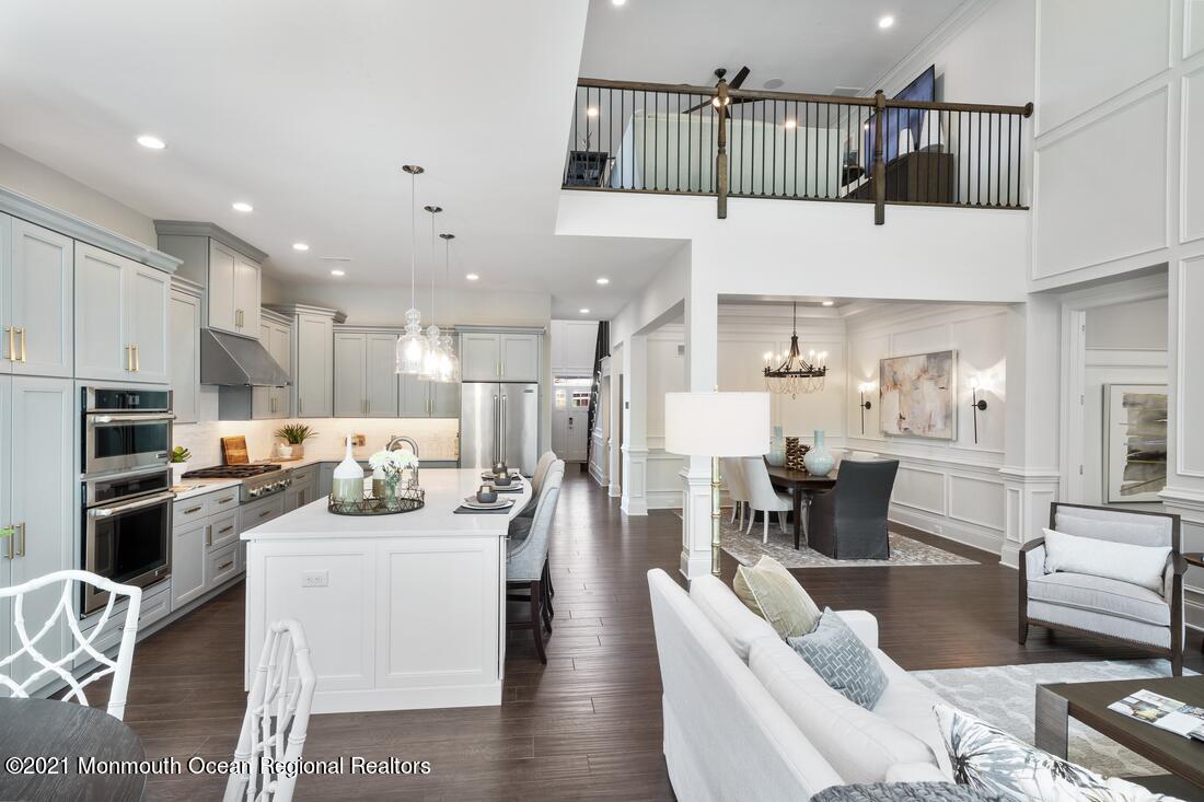 5 Old Eagle Road Freehold, NJ 07728 - Photo 6 of 17 a kitchen with stainless steel appliances kitchen island granite countertop a living room dining room cabinets and couches with wooden floor