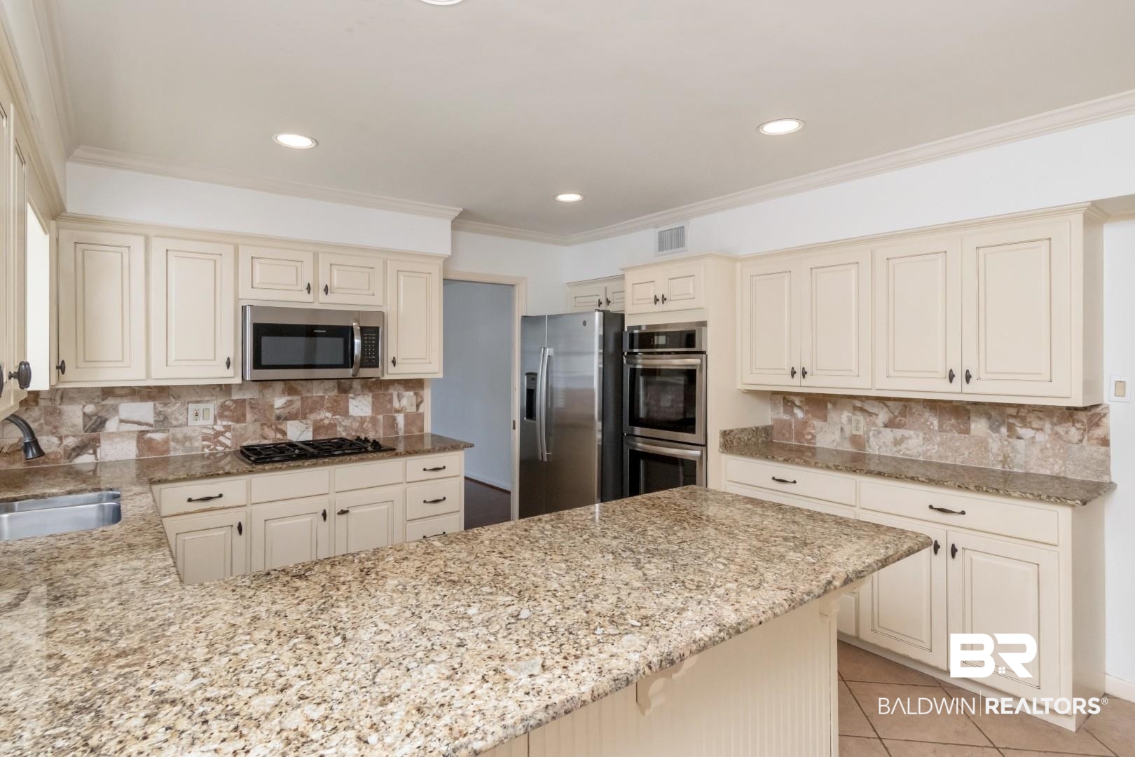 3755 Claridge Road North Mobile, AL 36608 - Photo 8 of 38 Kitchen with appliances with stainless steel finishes, light stone countertops, backsplash, cream cabinetry, and crown molding