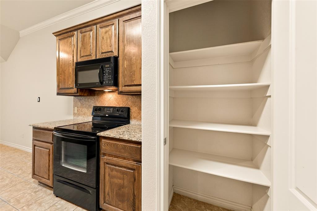 2105 Ridgewood Drive Bridgeport, TX 76426 - Photo 15 of 27 Kitchen area featuring wood cabinetry, granite-style countertops, and a tile backsplash