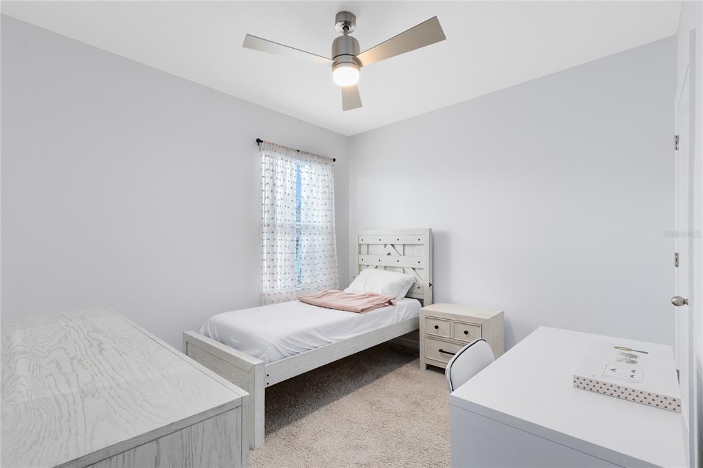 1600 Spray Terrace St. Cloud, FL 34771 - Photo 14 of 30 a bedroom with a bed and a chandelier