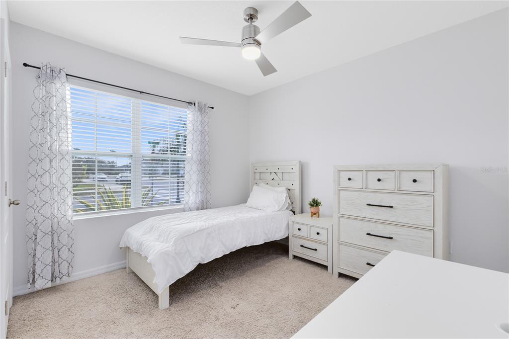 1600 Spray Terrace St. Cloud, FL 34771 - Photo 16 of 30 a bedroom with a bed a chandelier and a window