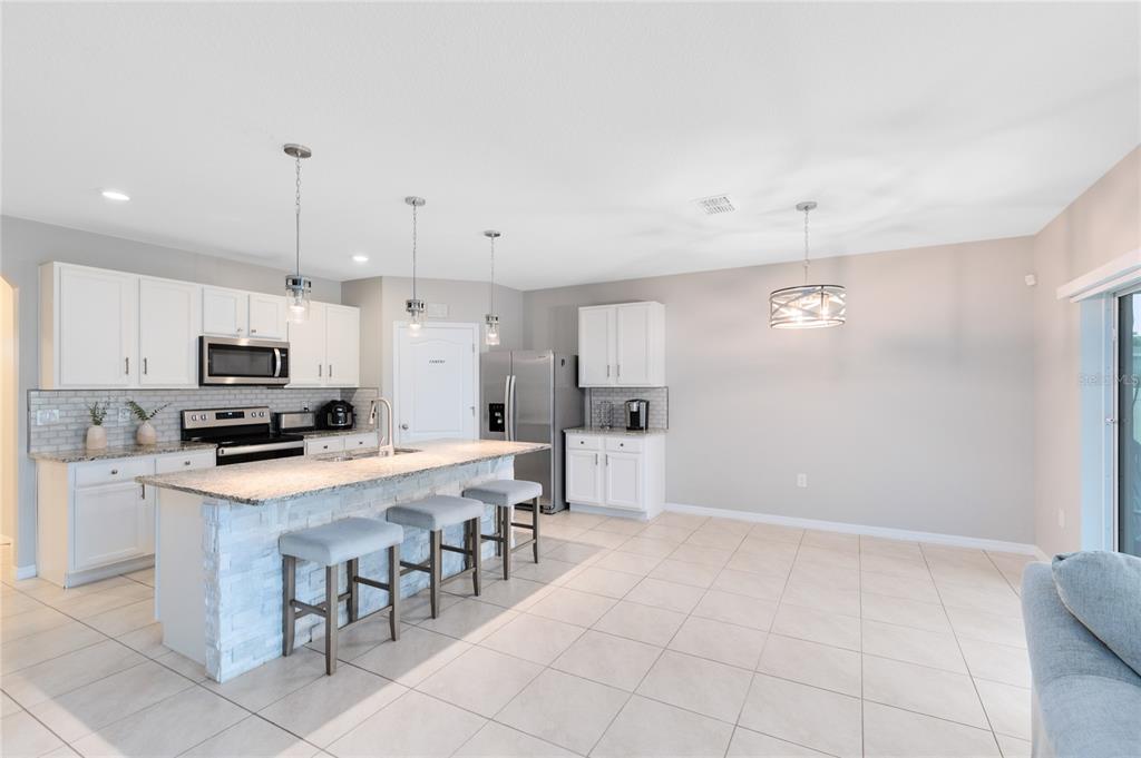 1600 Spray Terrace St. Cloud, FL 34771 - Photo 4 of 30 a kitchen with stainless steel appliances a stove top oven a refrigerator a sink and a refrigerator