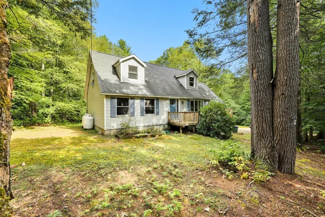 a view of a house with a yard and tree s