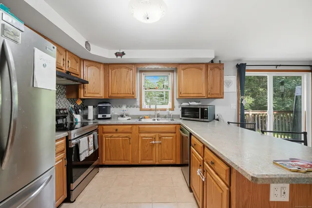 a kitchen with stainless steel appliances granite countertop a stove a sink and a refrigerator