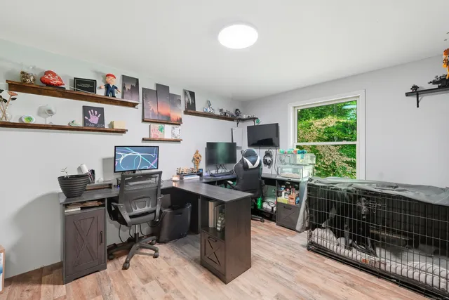 a view of a workspace with furniture and a window