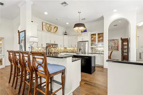 a kitchen with a sink cabinets and wooden floor