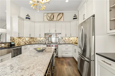 a kitchen with granite countertop a sink stainless steel appliances a window and counter space