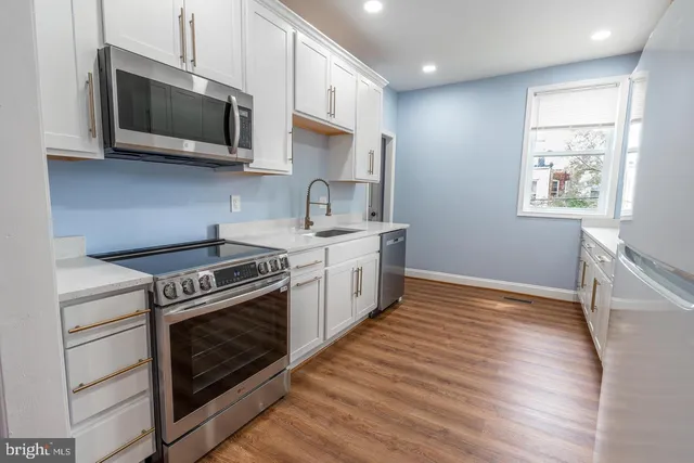a kitchen with stainless steel appliances a stove microwave and sink