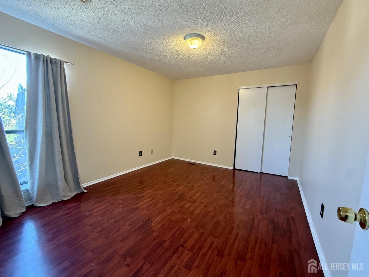 136 Westgate Drive Edison, NJ 08820 - Photo 12 of 17 an empty room with wooden floor and windows