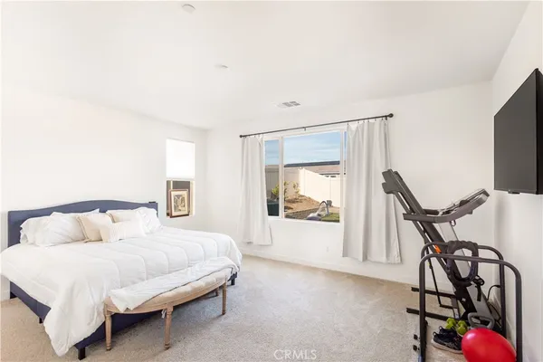 a bedroom with furniture and a flat screen tv