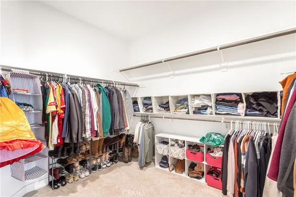 a view of walk in closet with clothes and shoes
