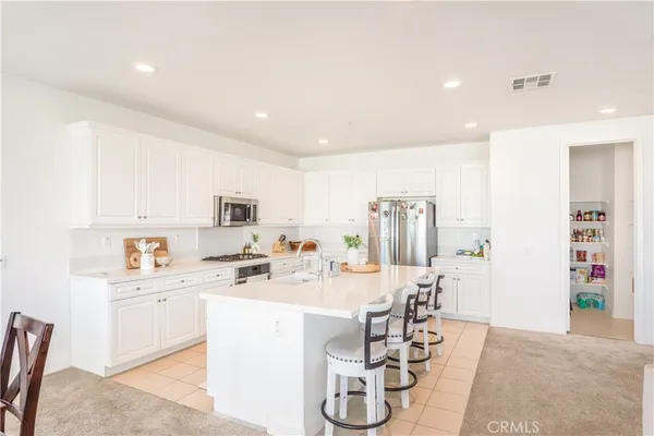 a room with stainless steel appliances a sink a counter top space and cabinets