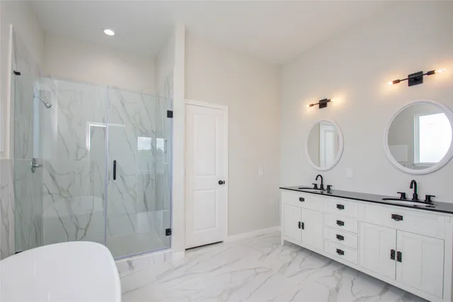 a bathroom with double vanity sink a mirror and a shower