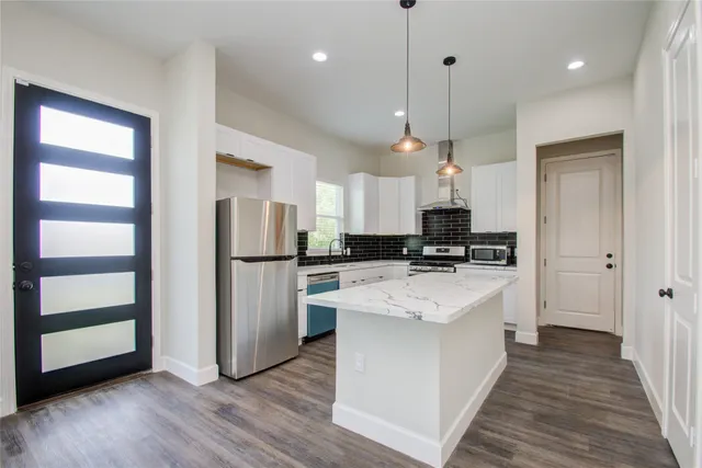 a kitchen with stainless steel appliances kitchen island a refrigerator sink and stove