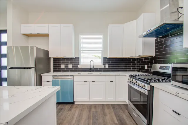 a kitchen with granite countertop a sink stainless steel appliances a counter space and cabinets
