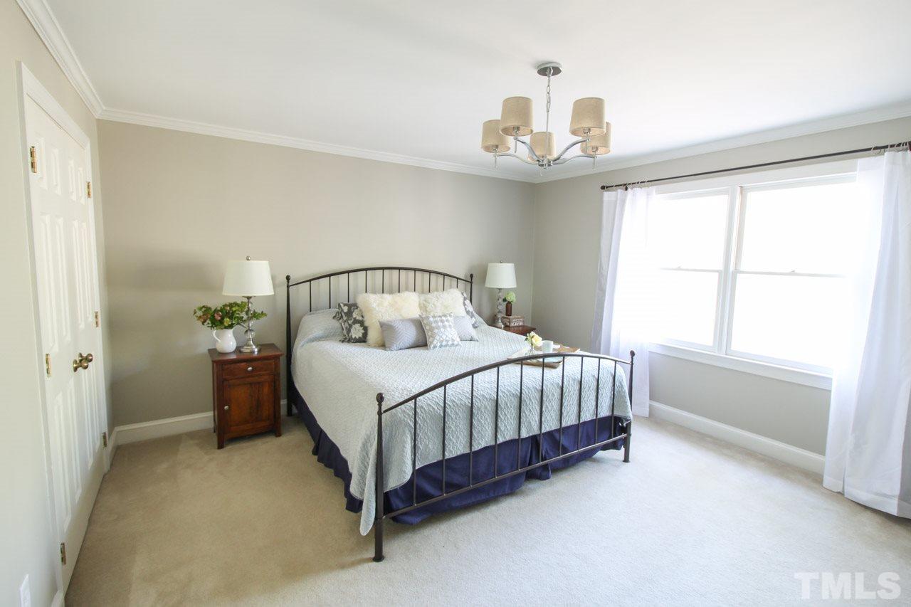 8805 Bickley Place Raleigh, NC 27613 - Photo 14 of 25 a bedroom with a bed chandelier and a window
