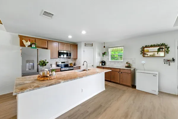 a kitchen with granite countertop kitchen island a sink and a stove