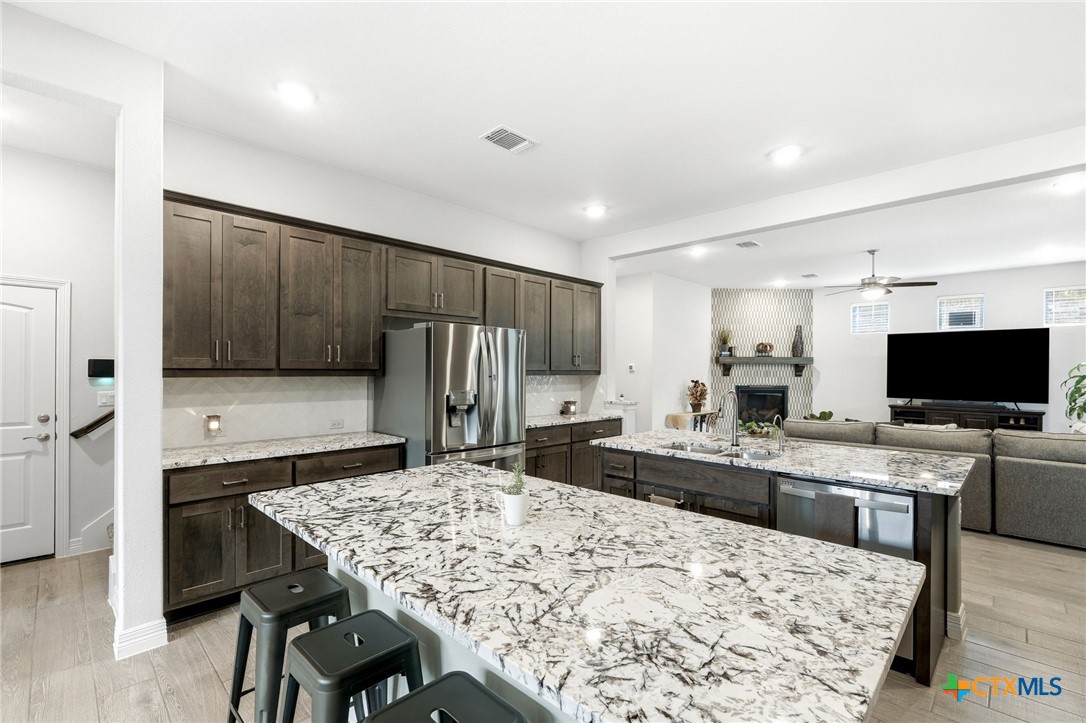 1209 Winding Way Drive Georgetown, TX 78628 - Photo 12 of 37 a kitchen with stainless steel appliances kitchen island granite countertop a sink and a refrigerator