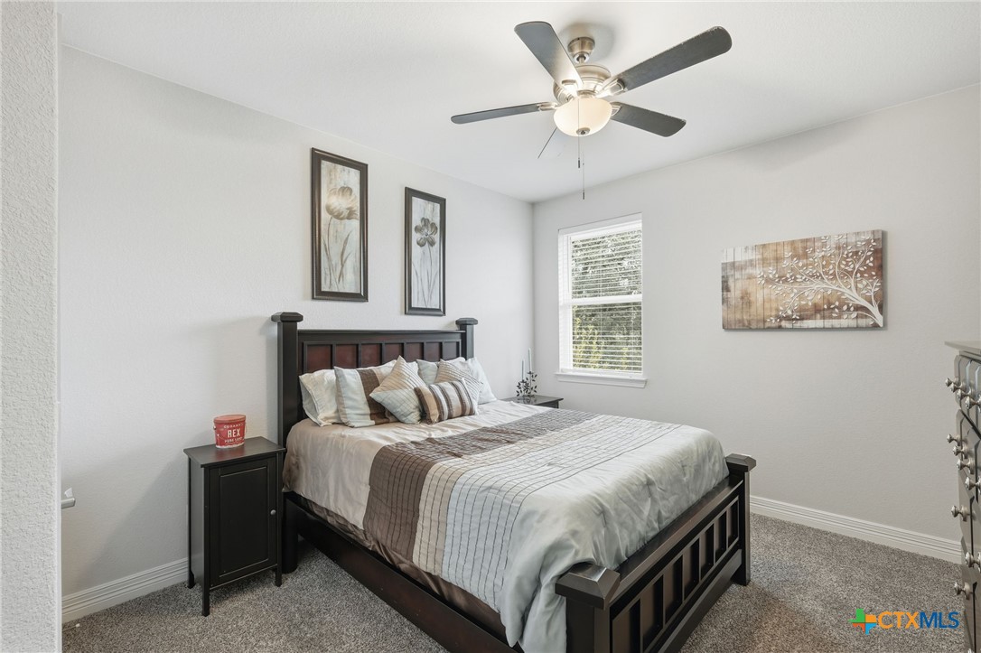 1209 Winding Way Drive Georgetown, TX 78628 - Photo 19 of 37 a bedroom with a bed and a ceiling fan