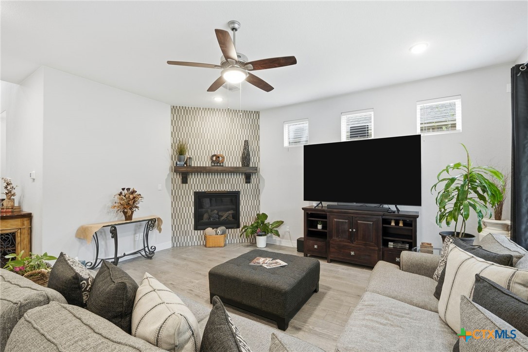1209 Winding Way Drive Georgetown, TX 78628 - Photo 8 of 37 a living room with furniture a fireplace and a flat screen tv