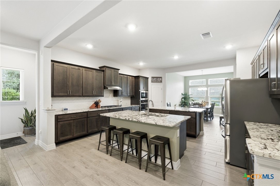 1209 Winding Way Drive Georgetown, TX 78628 - Photo 10 of 37 a kitchen with stainless steel appliances granite countertop a stove and a refrigerator