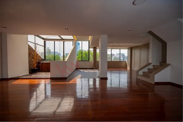 a living room with hardwood floor and large windows