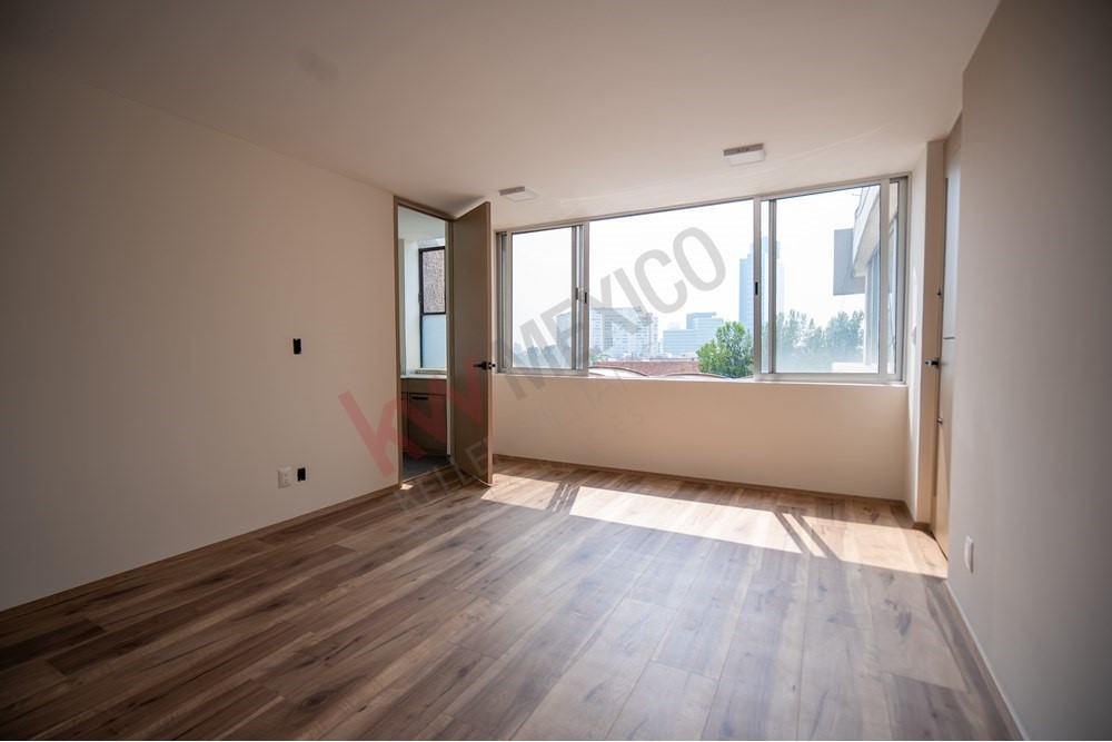 150 Viaducto Rio Becerra, Unit PH Alton Bay, CDMX 03810 - Photo 18 of 33 an empty room with wooden floor and windows