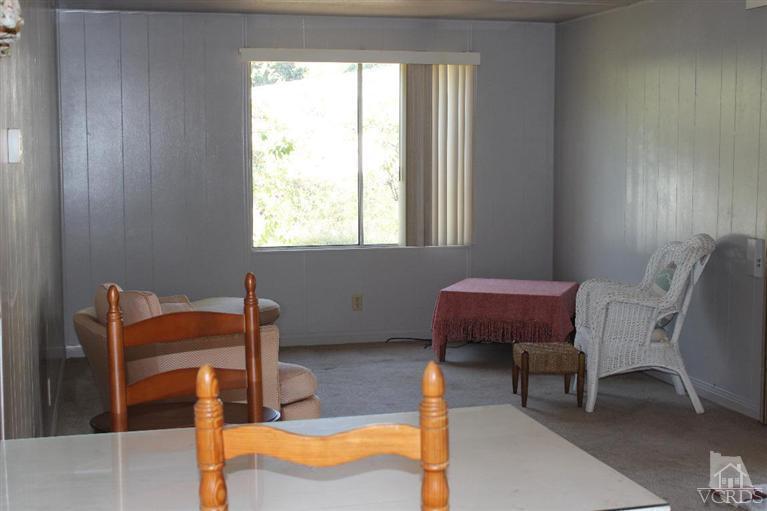 1225 South Rice Road, Unit 35 Ojai, CA 93023 - Photo 13 of 19 a blue chair sitting in a room next to a window