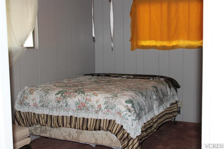 1225 South Rice Road, Unit 35 Ojai, CA 93023 - Photo 18 of 19 a bedroom with a bed and chair