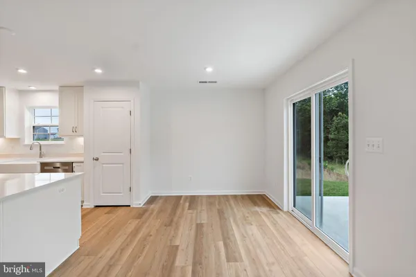 a view of a kitchen with wooden floor and a window