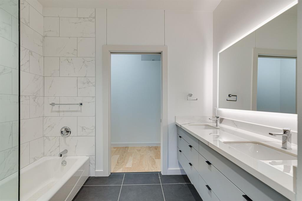 1023 Lipscomb Street, Unit 302 Fort Worth, TX 76104 - Photo 15 of 30 a bathroom with a double vanity sink mirror and bathtub