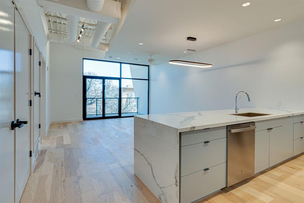 1023 Lipscomb Street, Unit 302 Fort Worth, TX 76104 - Photo 19 of 30 a view of a kitchen with a sink and wooden floor