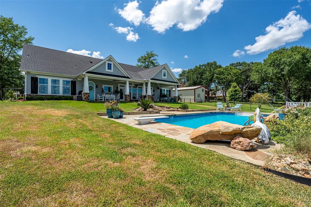 16241 Big Oak Bay Road Tyler, TX 75707 - Photo 34 of 40 Expansive backyard featuring a rectangular swimming pool with integrated diving board, flagstone coping, and surrounding flat stone patio