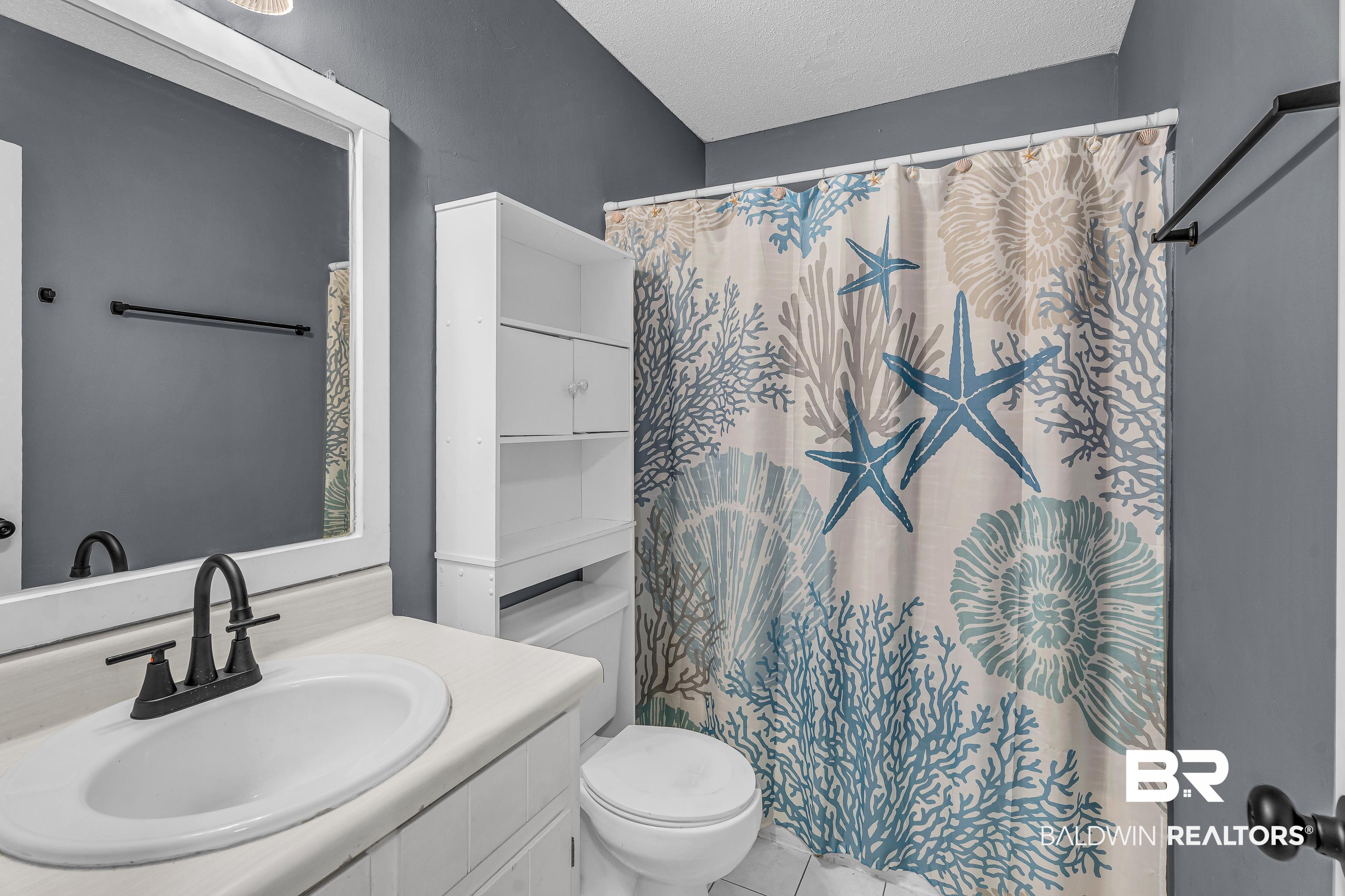 6135 Oak Cliff Drive Eight Mile, AL 36613 - Photo 25 of 30 Full bath featuring vanity, a textured ceiling, light tile patterned flooring, and curtained shower