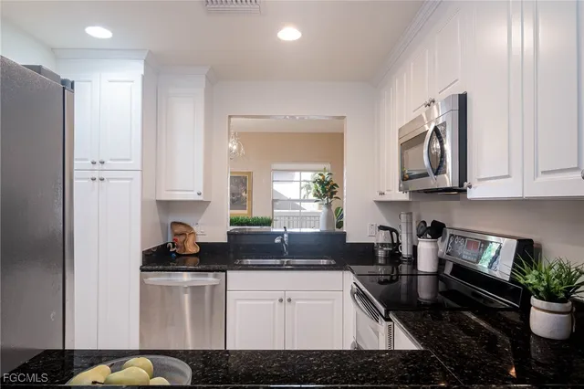 a kitchen with stainless steel appliances granite countertop a stove a sink and a refrigerator