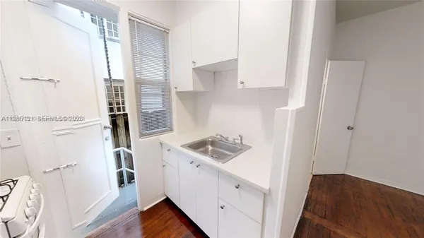 a kitchen with a sink a refrigerator and cabinets