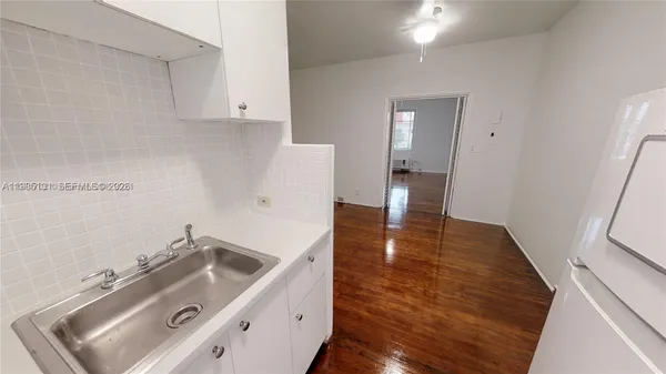 a view of a kitchen sink a stove and wooden floor