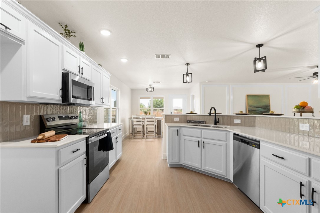 2115 Blackhawk Loop Belton, TX 76513 - Photo 11 of 26 a kitchen with granite countertop sink stainless steel appliances and white cabinets
