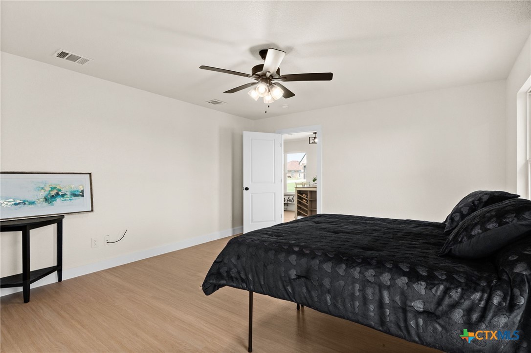 2115 Blackhawk Loop Belton, TX 76513 - Photo 14 of 26 a bedroom with a bed and a chandelier