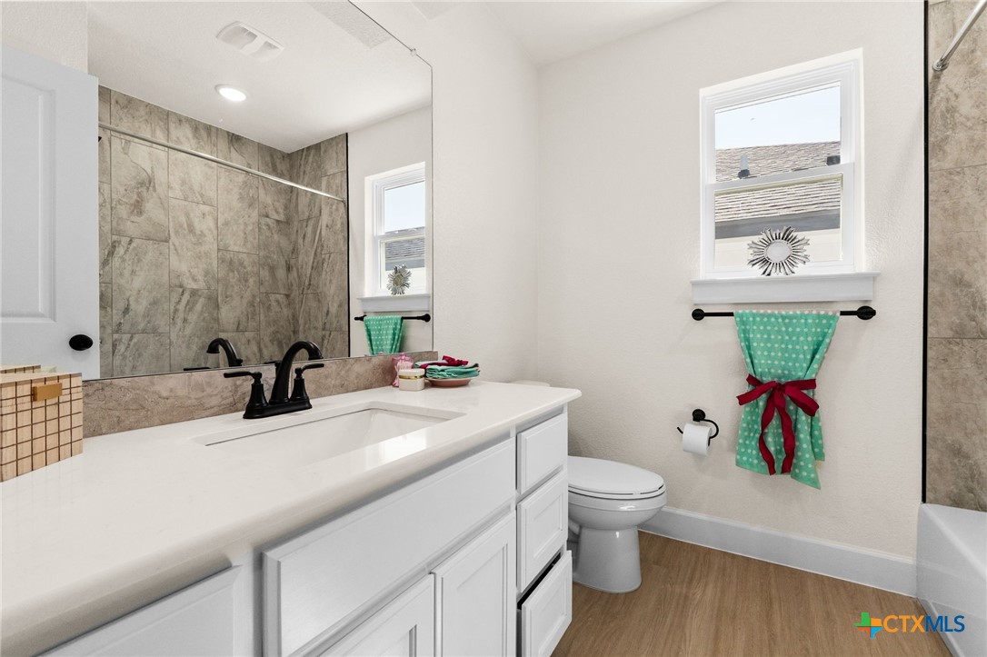 2115 Blackhawk Loop Belton, TX 76513 - Photo 21 of 26 a bathroom with a sink a toilet and a large mirror