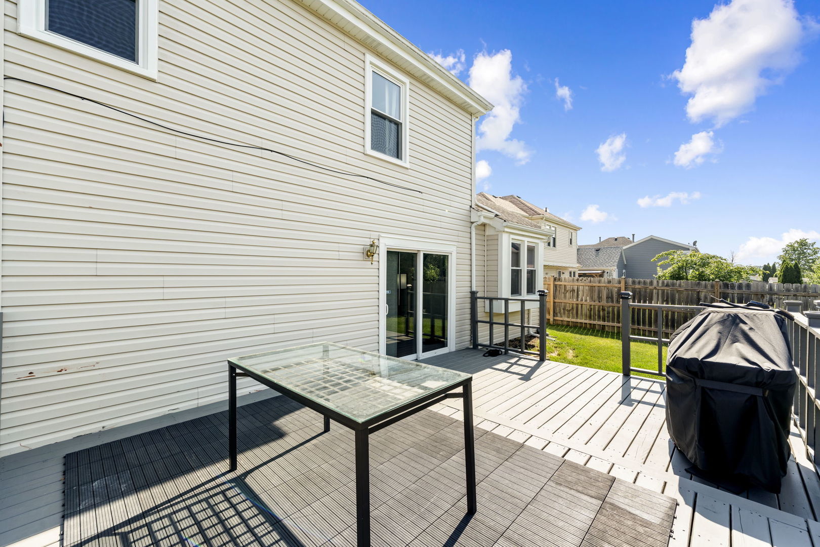 24 Fillmore Lane Streamwood, IL 60107 - Photo 26 of 35 a view of a patio with table and chairs with wooden floor and fence