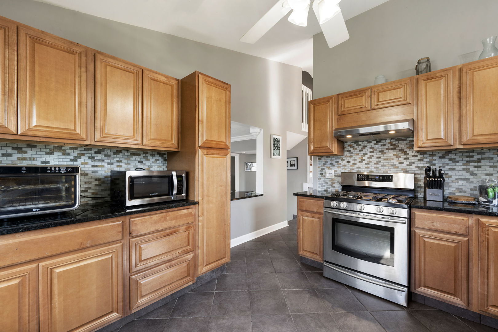 24 Fillmore Lane Streamwood, IL 60107 - Photo 9 of 35 a kitchen with granite countertop a stove top oven microwave and cabinets