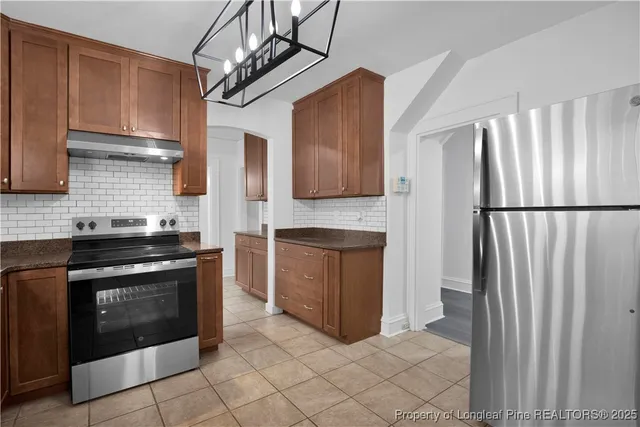 a kitchen with stainless steel appliances granite countertop a refrigerator a stove a sink and dishwasher
